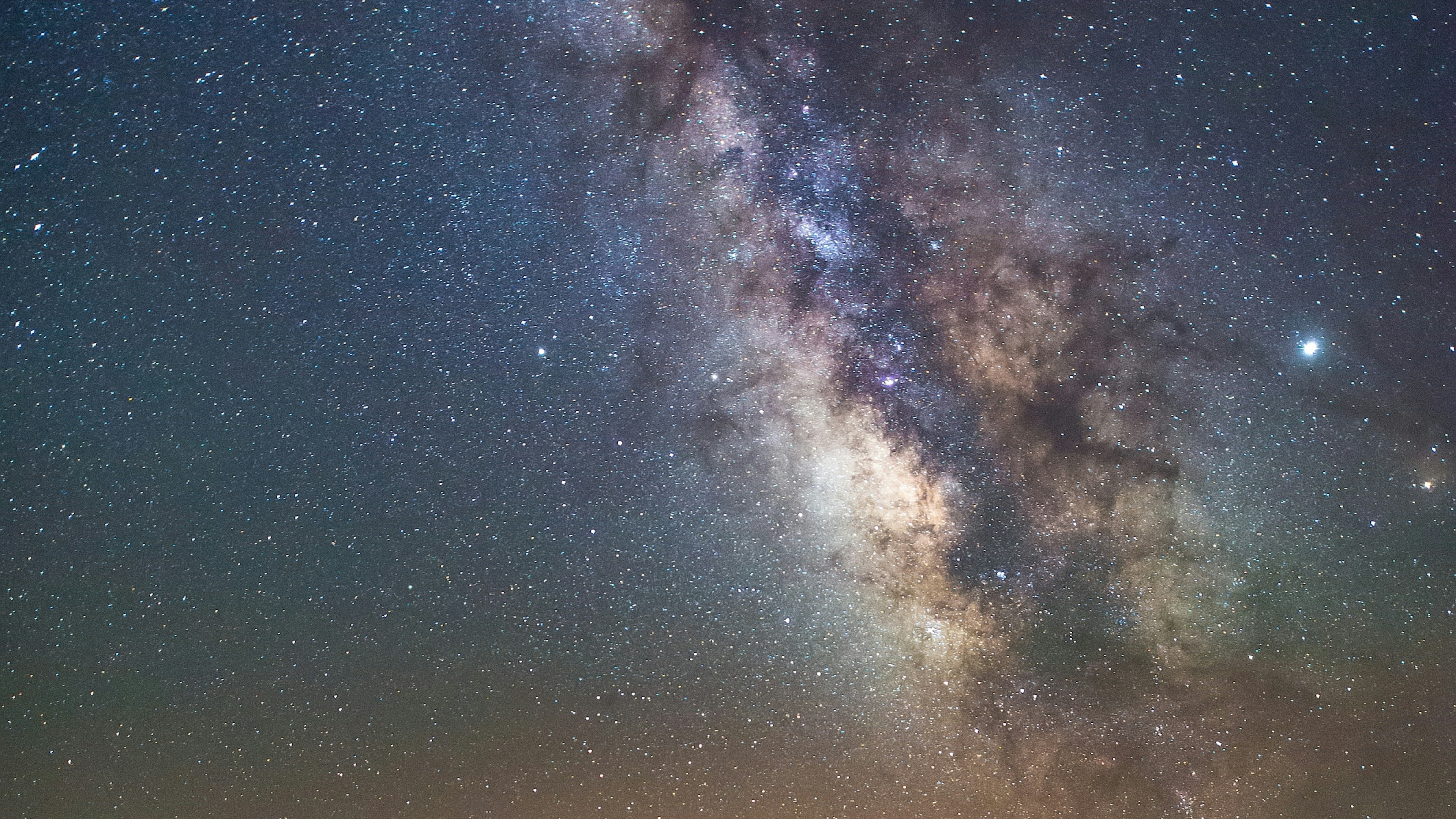 The core of the Milky Way galaxy over a starry night sky