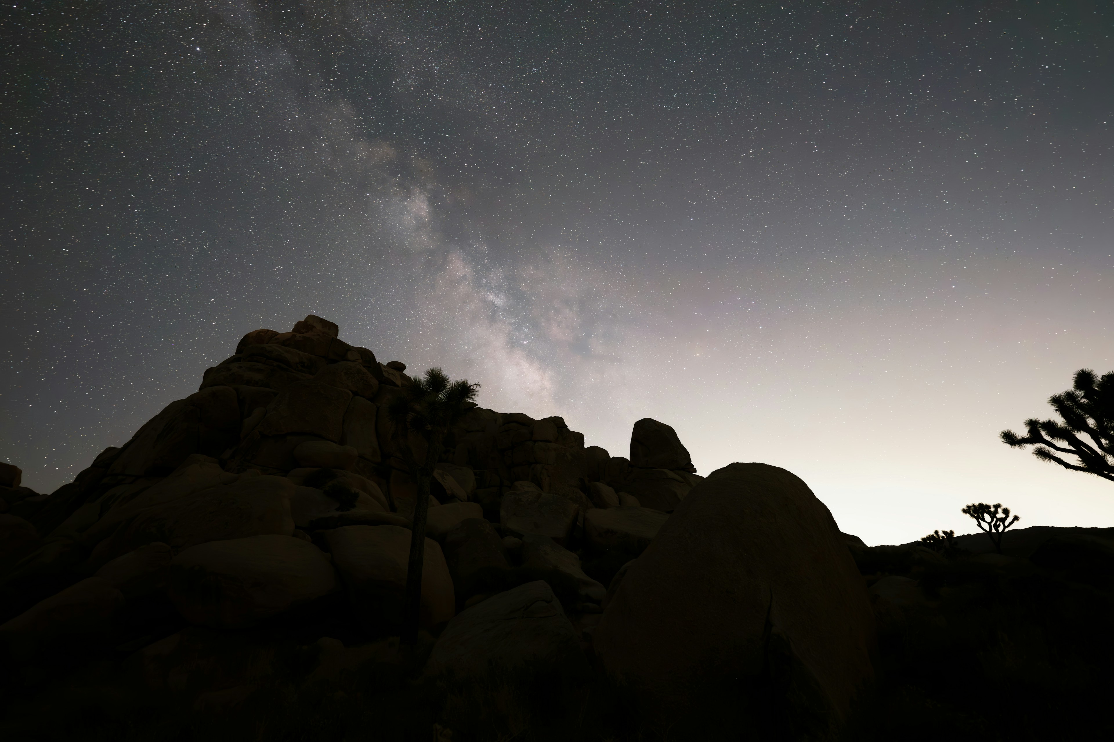 The Milky Way rising over a desert rock formation at night