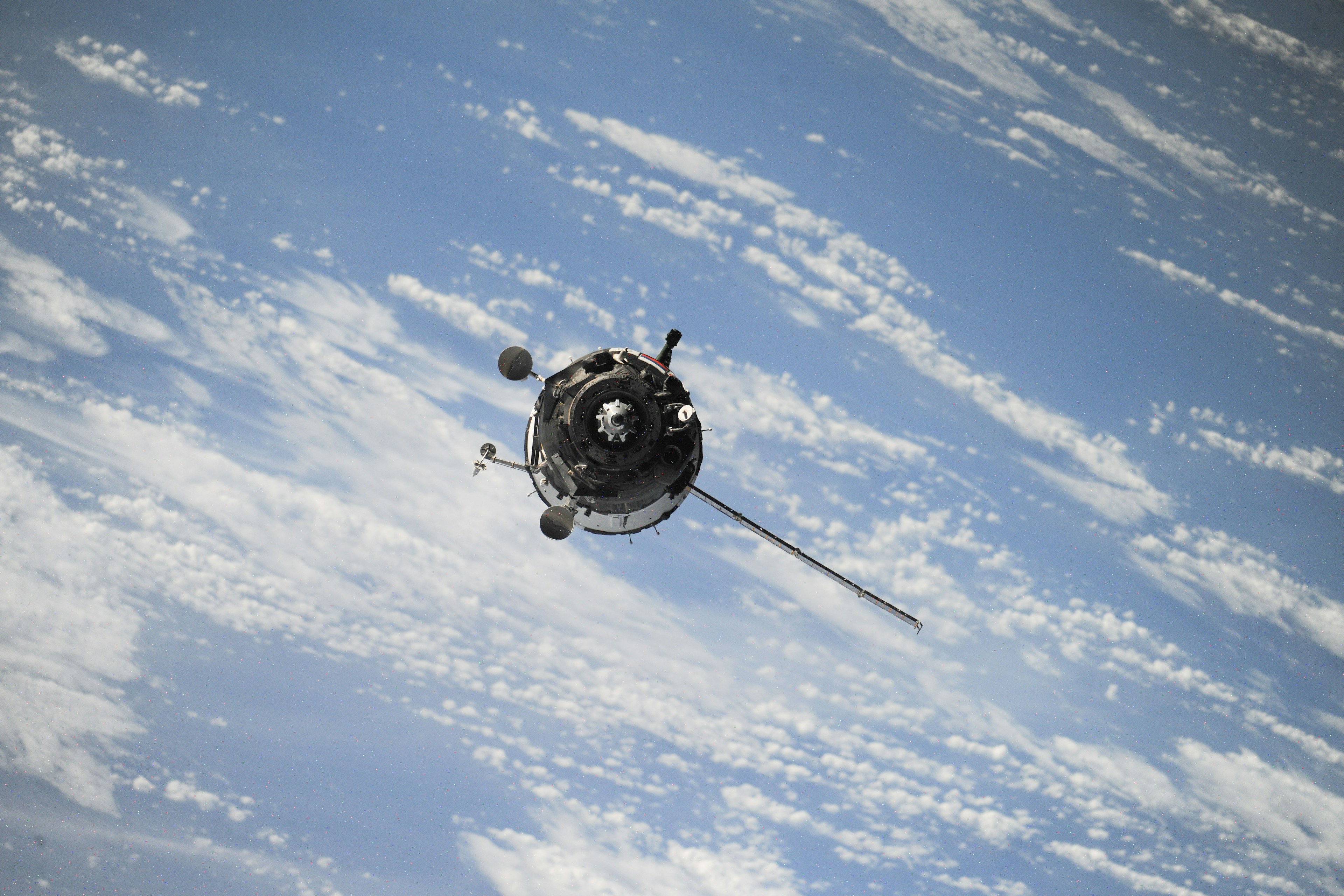 A spacecraft in orbit above Earth's clouds